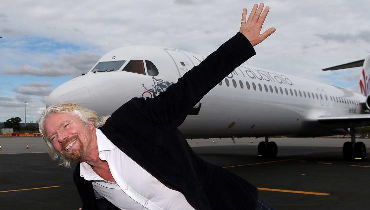 Richard Branson imitující letící letadlo